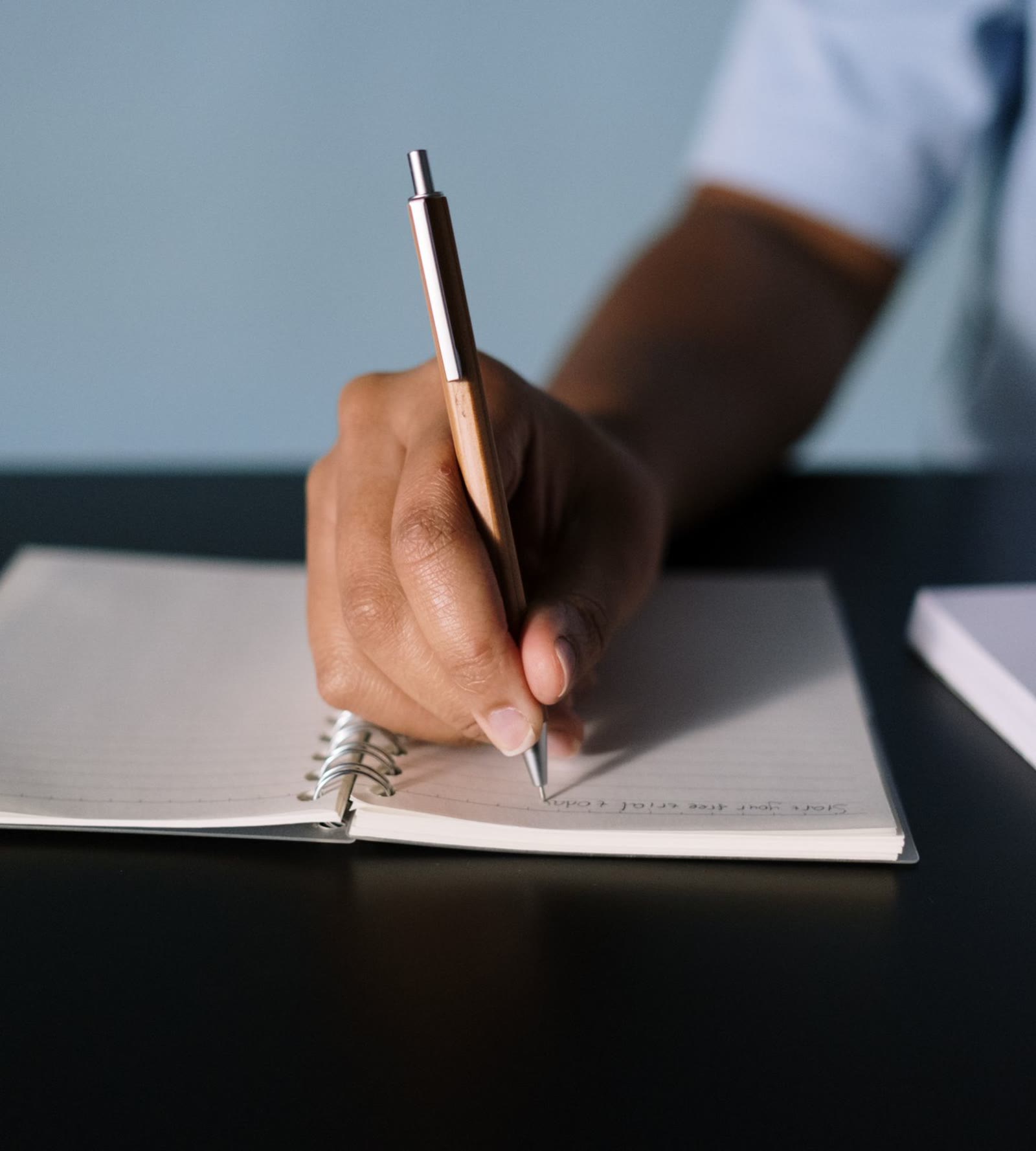 A hand working the problem out on paper